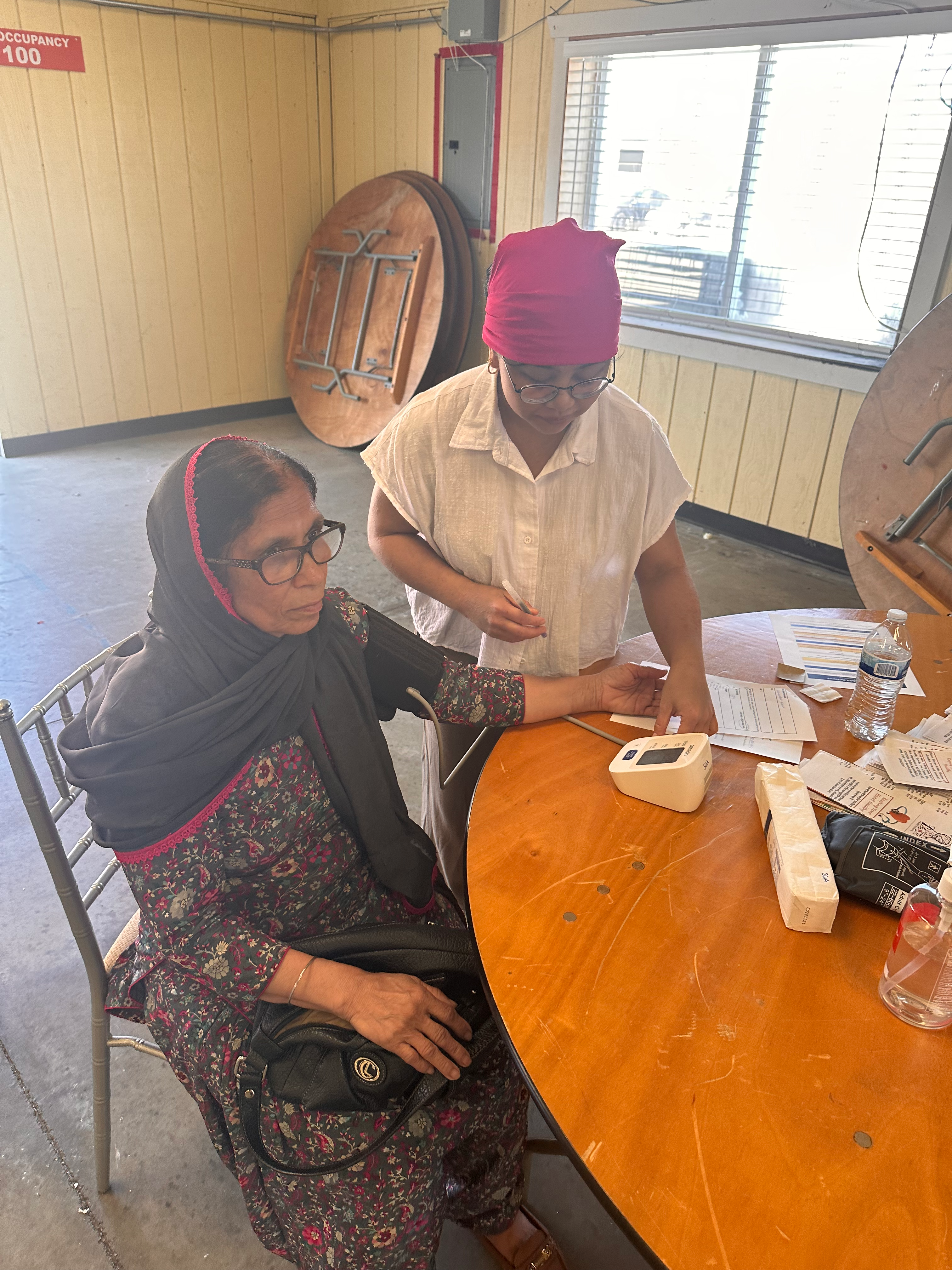 Community members receiving health screenings at registration table