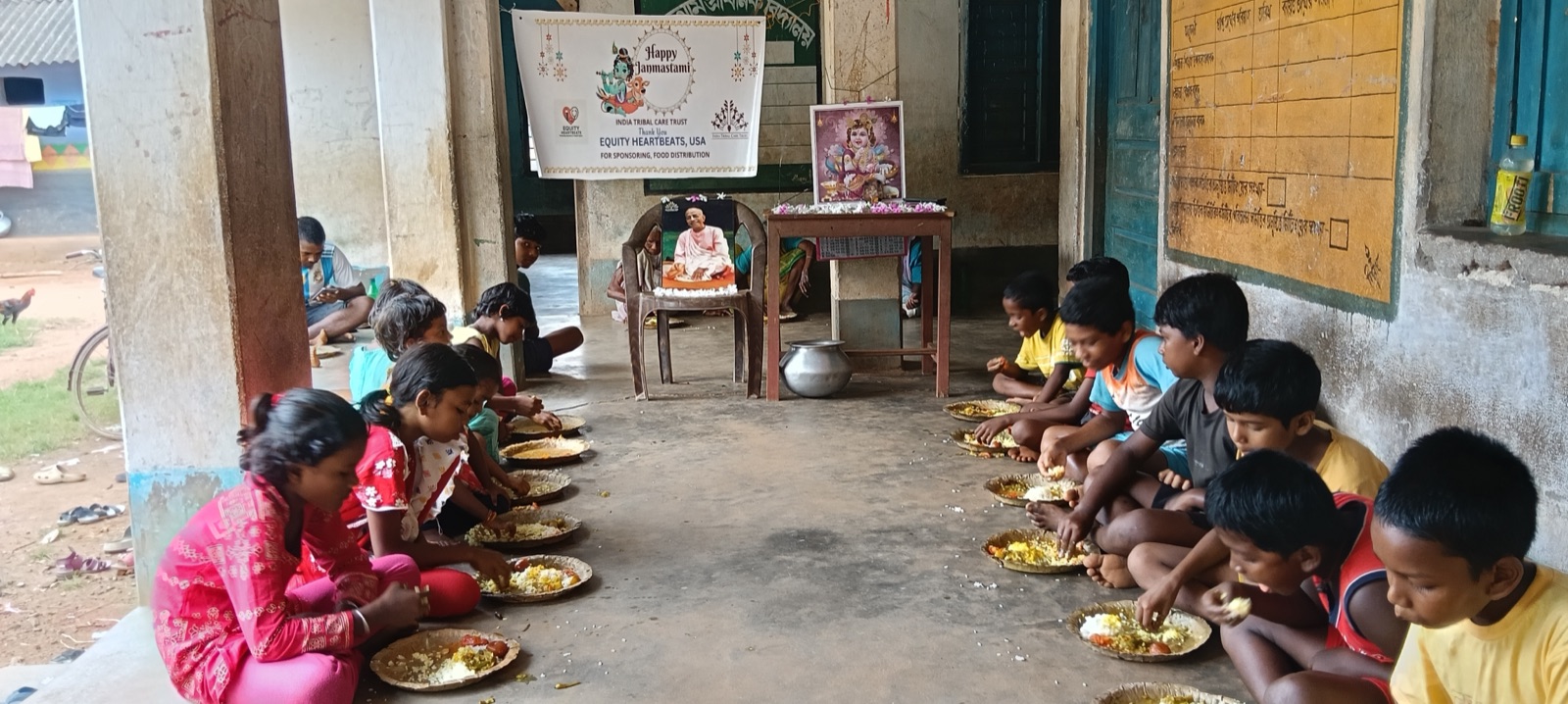 Children eating beneath a banner thanking Equity Heartbeats for sponsoring the meal
